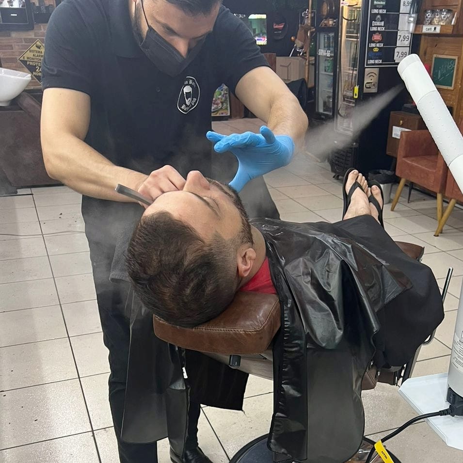 Michel, barbeiro do Clube da Barba, fazendo barba na navalha